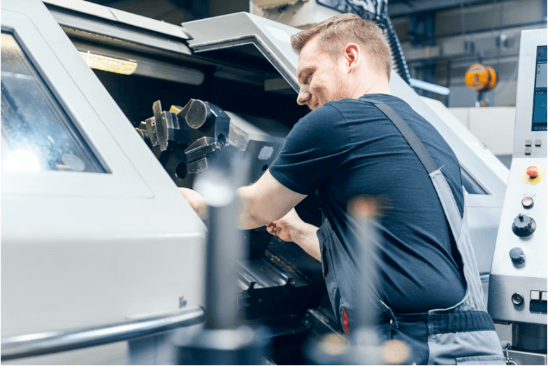 Workers and robotic arms on a modern manufacturing floor